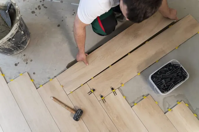 Top View Man Tiling Floor X - Certified Flooring Installer study guide