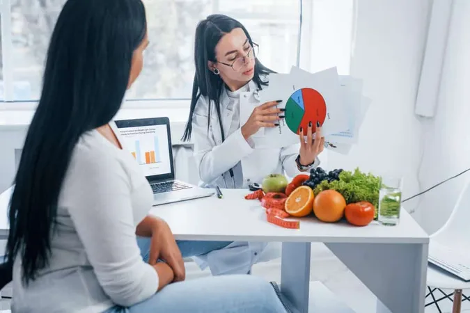 Female Nutritionist With Graph Gives Consultation Patient Indoors Office X - Clinical Lipid Specialist Certification study guide