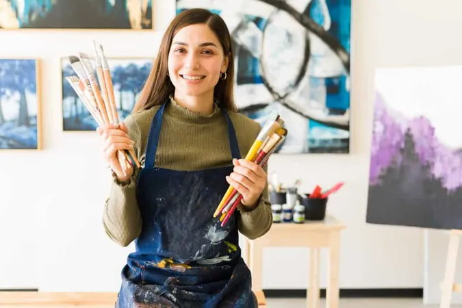 Smiling Latin Young Artist With Apron Holding Lot Painting Brushes Pretty Female Painter Sitting Bench Her Art Studio X - Certified Artist study guide