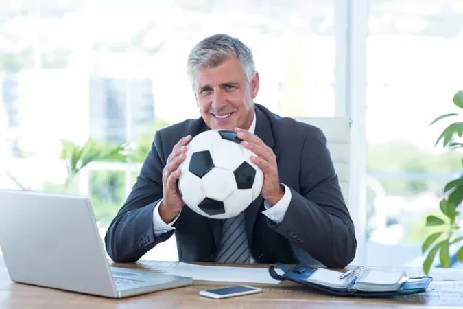 Smiling Businessman Holding Soccer Ball X - Certified Athletic Administrator study guide