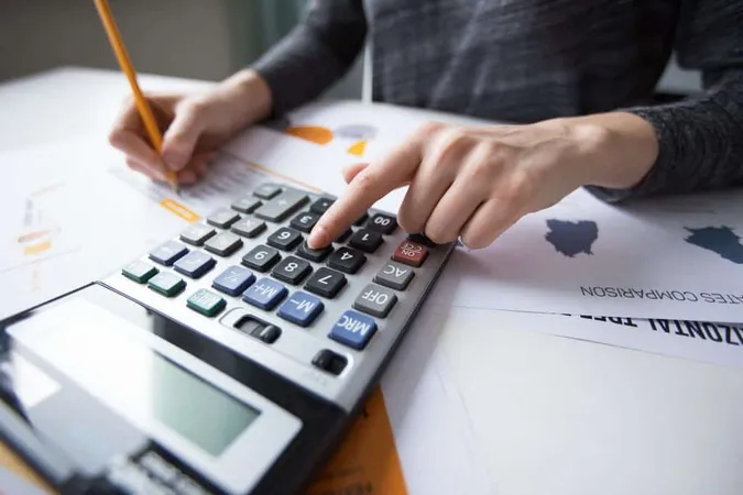 Close Up Female Hand Counting With Calculator X - Certified Cost Controller study guide