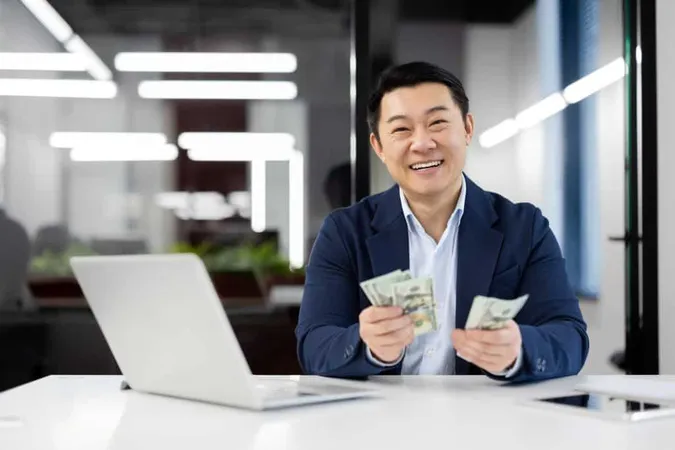 Happy Businessman Counting Money Modern Office Desk X - Certified Cash Manager study guide