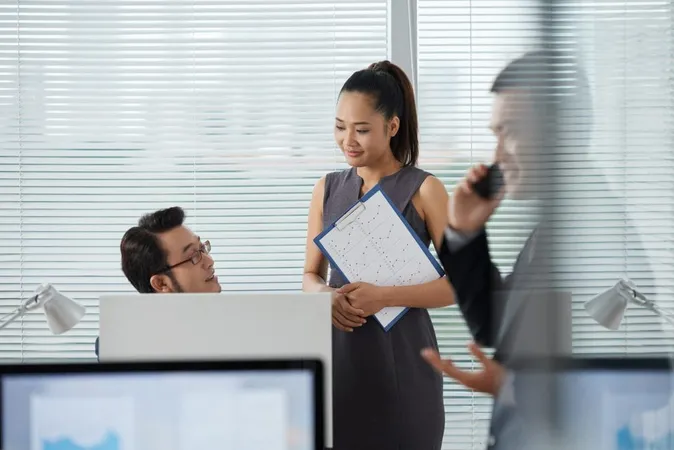 Asian Coworkers Discussing Something While Their Colleague Talking Phone X - Certified Customized Staffing study guide