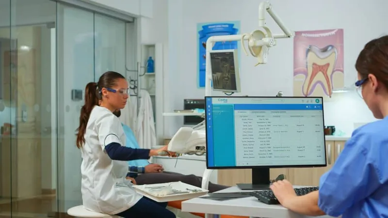 Nurse Typing Computer Making Appointments While Dental Specialist Talking Patient Stomatology Chair Before Examination Dentist Nurse Working Together Modern Stomatological Clinic X - Certified Dental Coder study guide