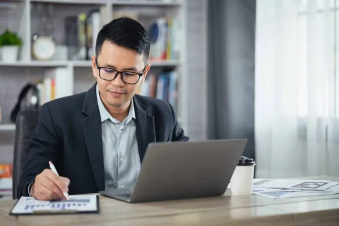 Young Man Using Laptop Office X - Certified General Accountant study guide