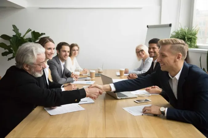 Senior Investor Buying Startup Handshaking Young Entrepreneur Group Meeting X - Certified Meeting Professional study guide