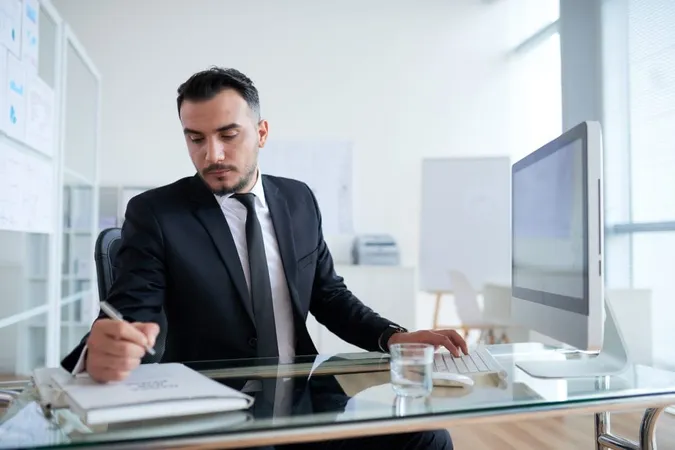 Caucasian Businessman Sitting Desk Front Computer Writing Document Folder X - Certified Practicing Accountant study guide