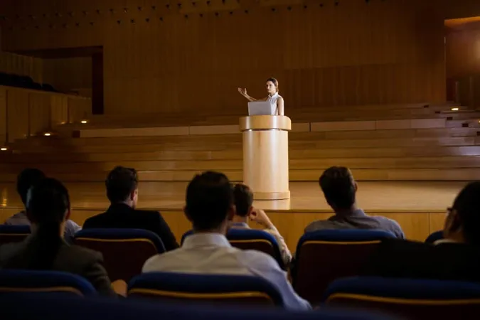 Female Business Executive Giving Speech 2 X - Certified Public Communicator study guide