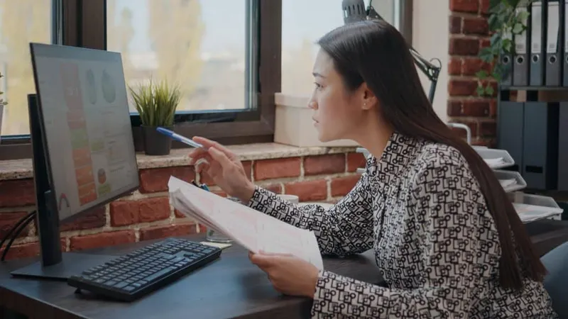 Asian Woman Comparing Charts Papers Computer Working Plan Business Project Startup Office Company Employee Analyzing Documents Design Financial Data Str X - Certified Professional Organizer study guide