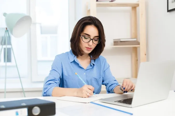 Pretty Brunette Girl Is Working Table Office She Wears Blue Shirt Black Glasses She Is Writing Seriously 2 X - Certified Professional Proofreader study guide