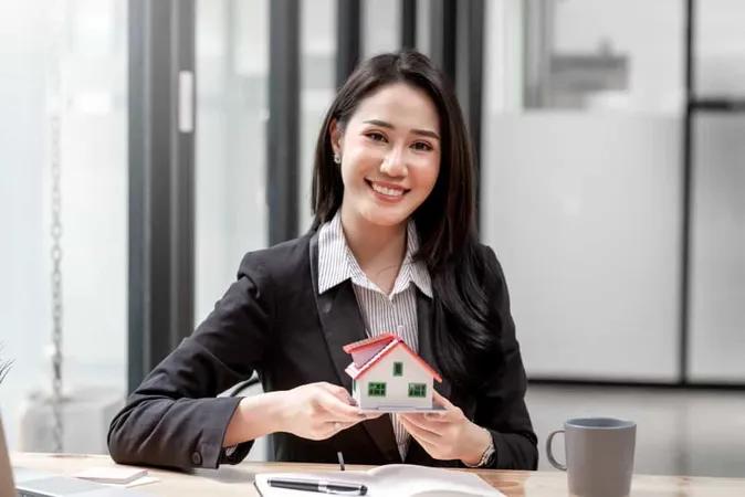 Miniature House Hands Asian Woman Real Estate Agent Home Loan Working Office Looking Camera X - Commercial Real Estate Certification Institute study guide