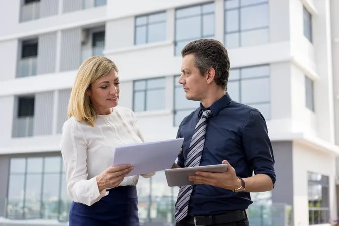 Business Partners Discussing Documents Outdoors 1 X - Certified Residential Manager study guide