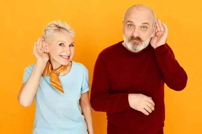 Snoopy Senior Man With Thick Gray Beard Posing Isolated With His Attractive Nosy Blonde Wife Holding Hands Ear Trying Overhear Private Conversation Secret Curious News Eavesdropping 1 X - Hearing Aid Certification study guide