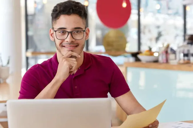 Satisfied Man Works Clients Project Updates Software Sits Front Opened Laptop Computer Holds Document Keeps Hand Chin Models Cozy Cafeteria Interior Thinks Idea Startup X - HubSpot Administrator Certification study guide