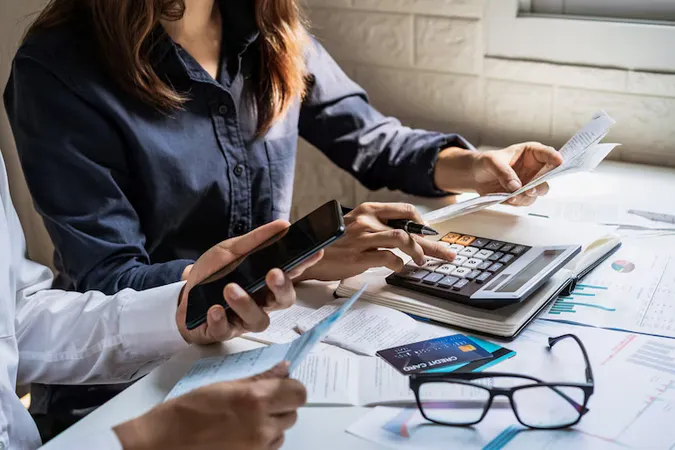 Stressed Young Couple Checking Bills Taxes Bank Account Balance Calculating Expenses Living Room - International Association of Bookkeepers Certification study guide