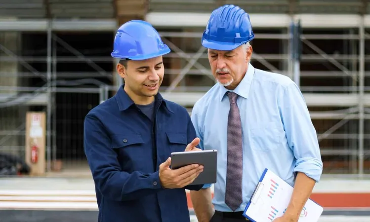 Two Architect Developers Reviewing Building Plans Construction Site Using Tablet X - Infrastructure Health &amp; Safety Association Certified Coach study guide