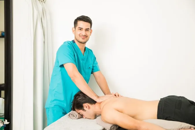 Confident Physical Therapist Giving Shoulder Massage Patient Lying Hospital X - Licensed Massage Therapists study guide