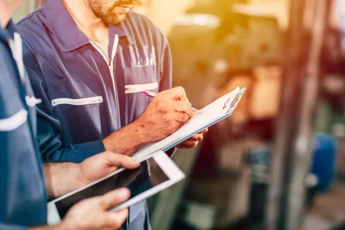 Worker Taking Note Using Pen Paper With New Young Engineer Using Computer Tablet Work Faster More Efficiency X - Maintenance Management Certification study guide