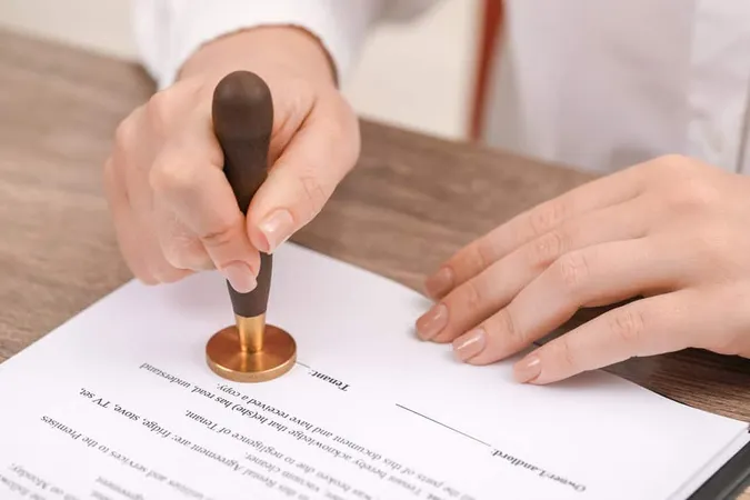 Woman Stamping Document Wooden T - Notary study guide