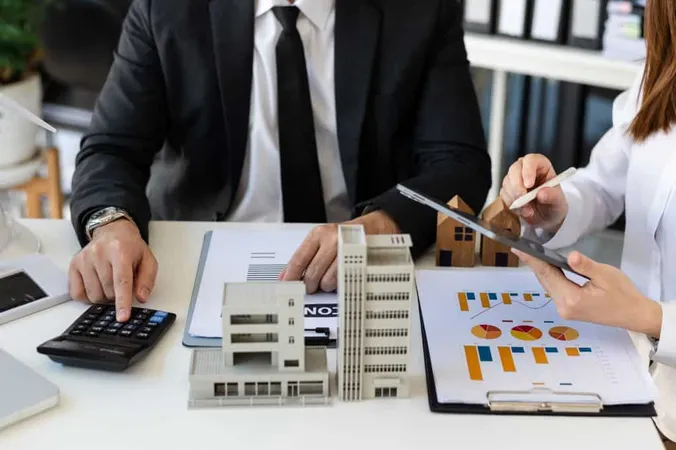 Real Estate Broker Agent Presenting Consult Customer Decision Making Sign Insurance Form Agreement Home Model Concerning Mortgage Loan Offer Office 2 X - Real Estate Analyst Certification study guide